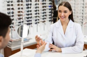An eye care professional handing a contact lens case with contact lenses to a patient.